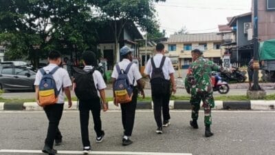 Peduli Keselamatan Anak Sekolah, Secara Rutin Babinsa Koramil Jajaran Kodim 1710/Mimika Bantu Seberangkan Jalan
