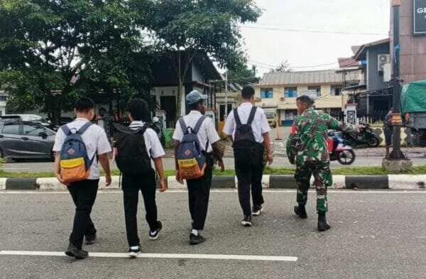 Peduli Keselamatan Anak Sekolah, Secara Rutin Babinsa Koramil Jajaran Kodim 1710/Mimika Bantu Seberangkan Jalan
