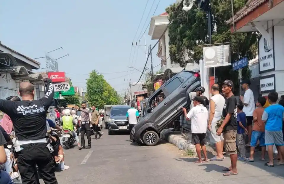 Suzuki S-Presso Tersangkut di Pagar Rumah Warga di Jombang